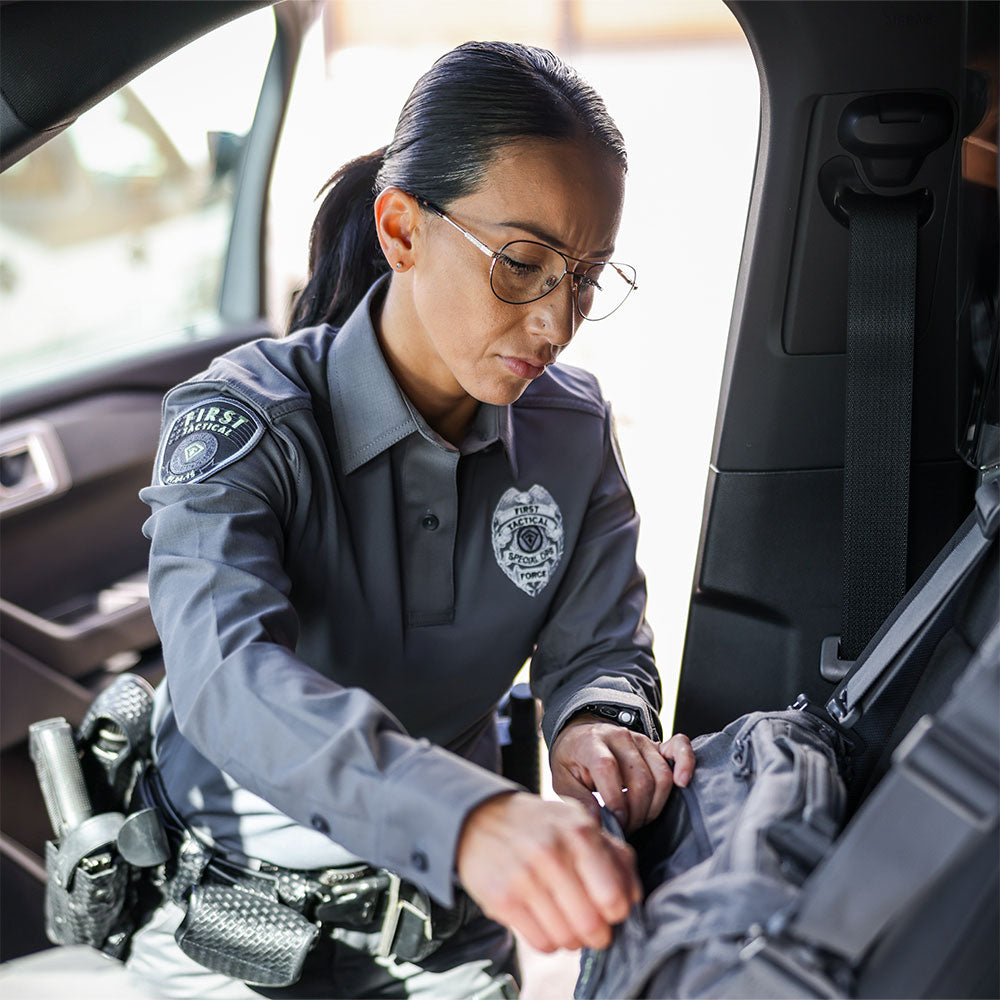Image of a woman officer wearing V2 pro  performance shirt going through bag