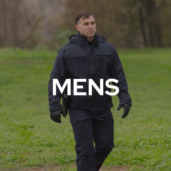 A man walking outdoors in a dark navy tactical-style jacket and matching pants, with large white text reading 'MENS' overlaid across the center.